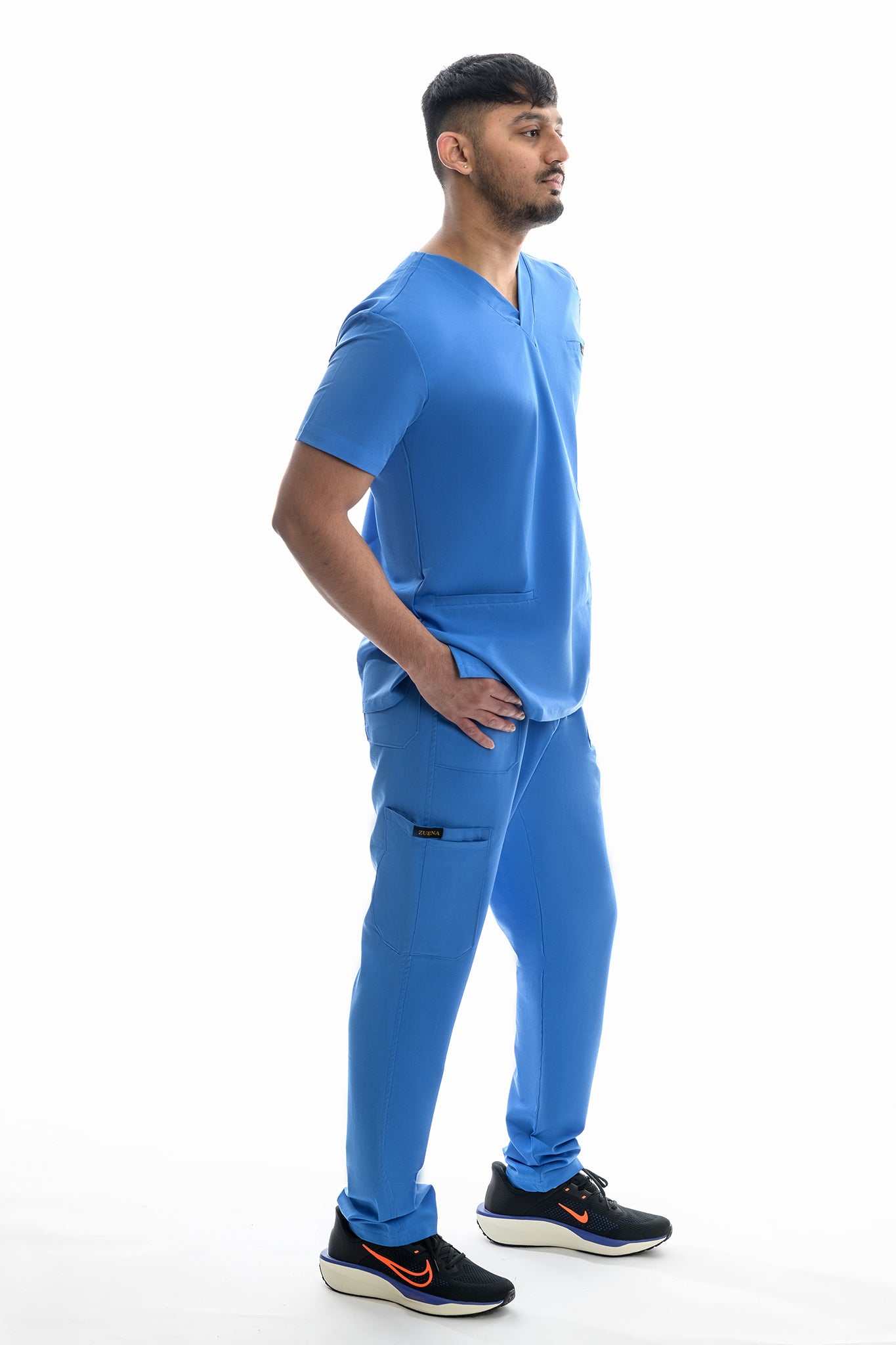Male model wearing blue Skyward Bound Scrub Set with short sleeves and straight leg pants against white background