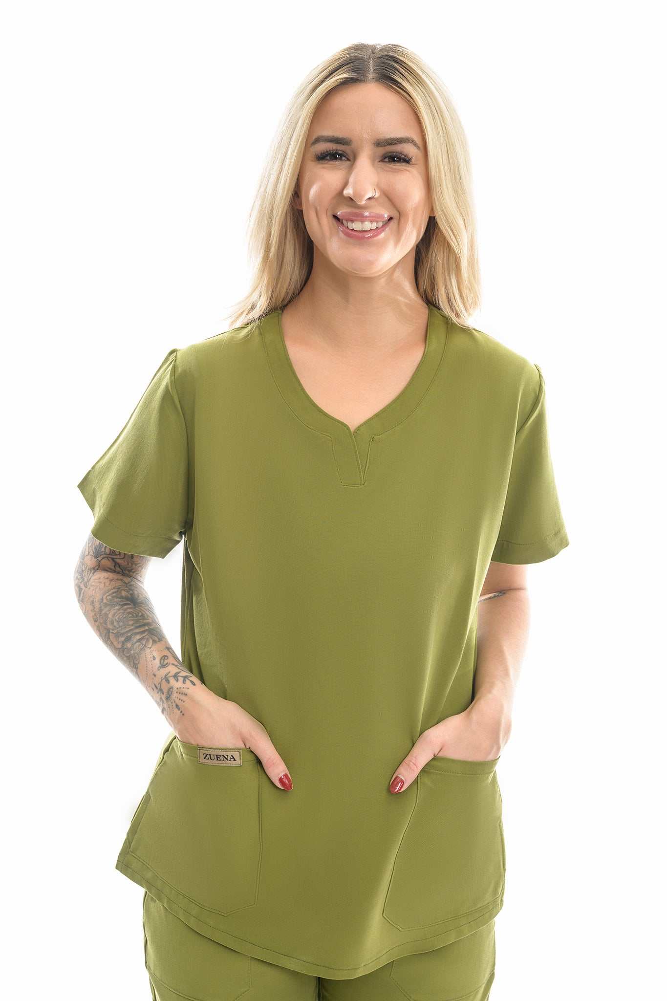 Woman wearing Zuena Olive Groove scrub top with curved neck, short sleeves, and multiple pockets