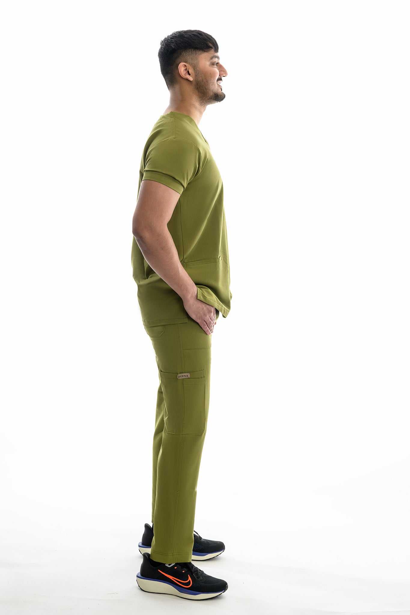 Man wearing Zuena Olive Scrub Set for men with five-pocket olive groove scrub pants and matching olive scrub top