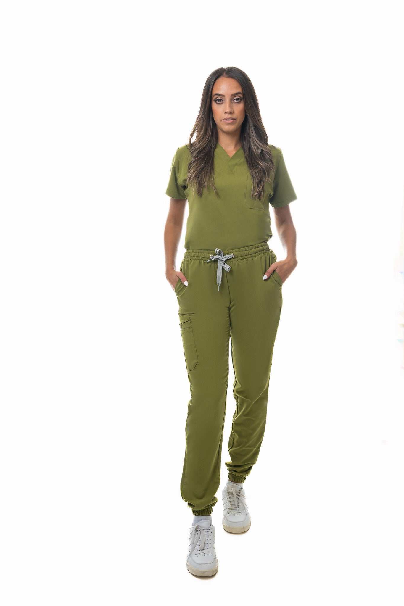 Woman wearing olive green Zuena Olive Grove scrub pants with elastic waistband and multiple pockets, styled for comfort and durability.