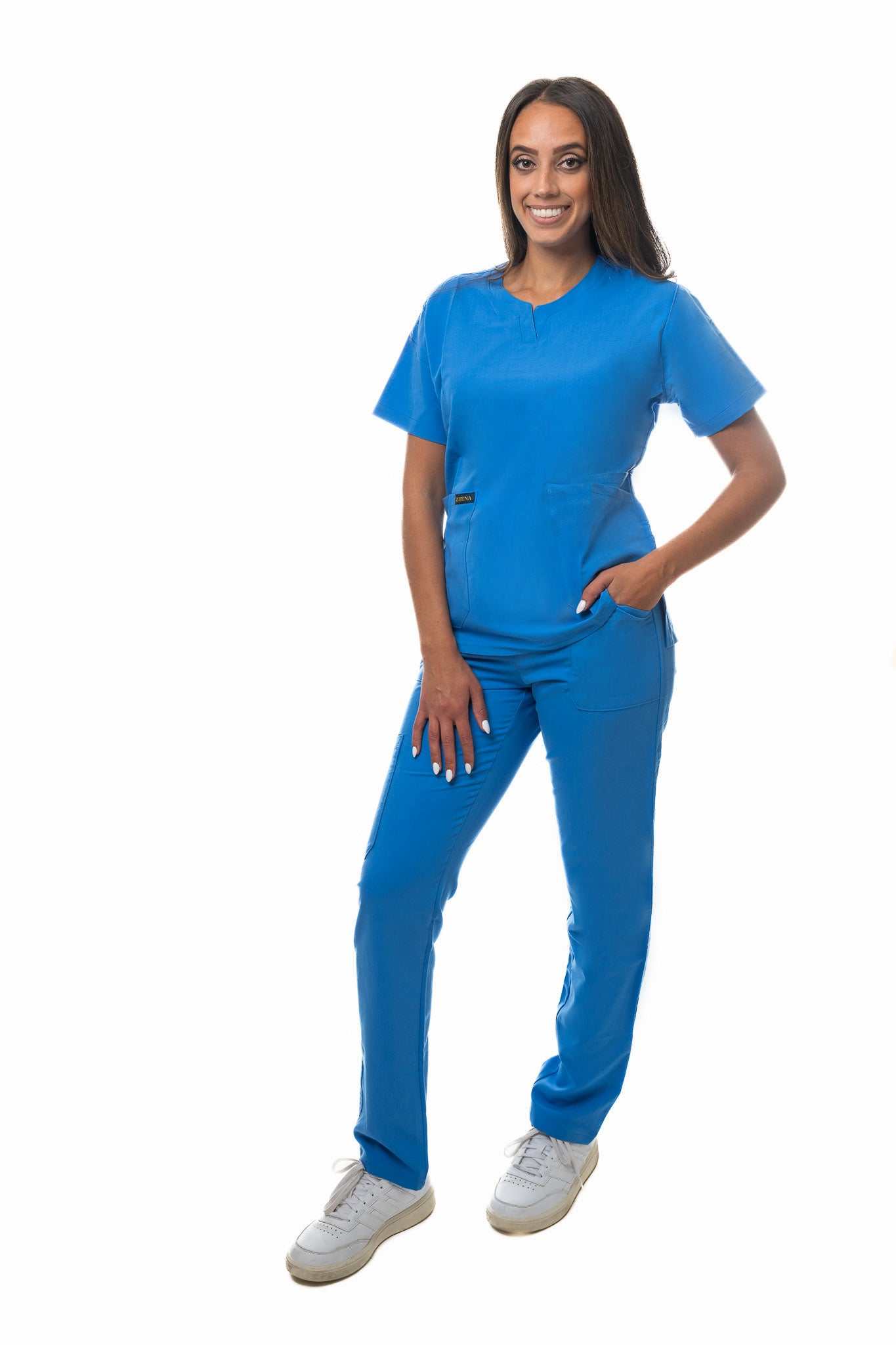 Woman wearing blue Zuena Skyward Bound scrub bottom with elastic waistband and multiple pockets, straight leg design for healthcare professionals