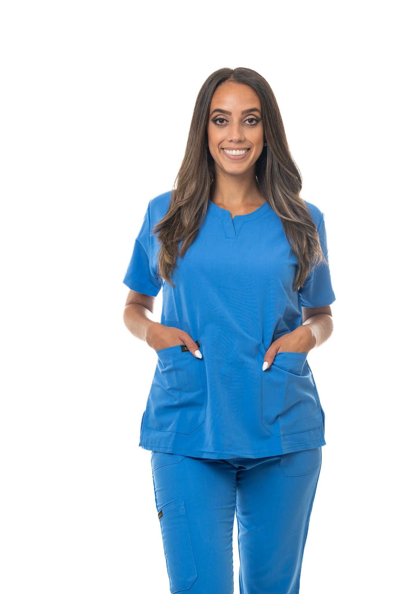 Woman wearing blue Skyward Bound Scrub Top with curved neck, short sleeves, side vents, and three pockets