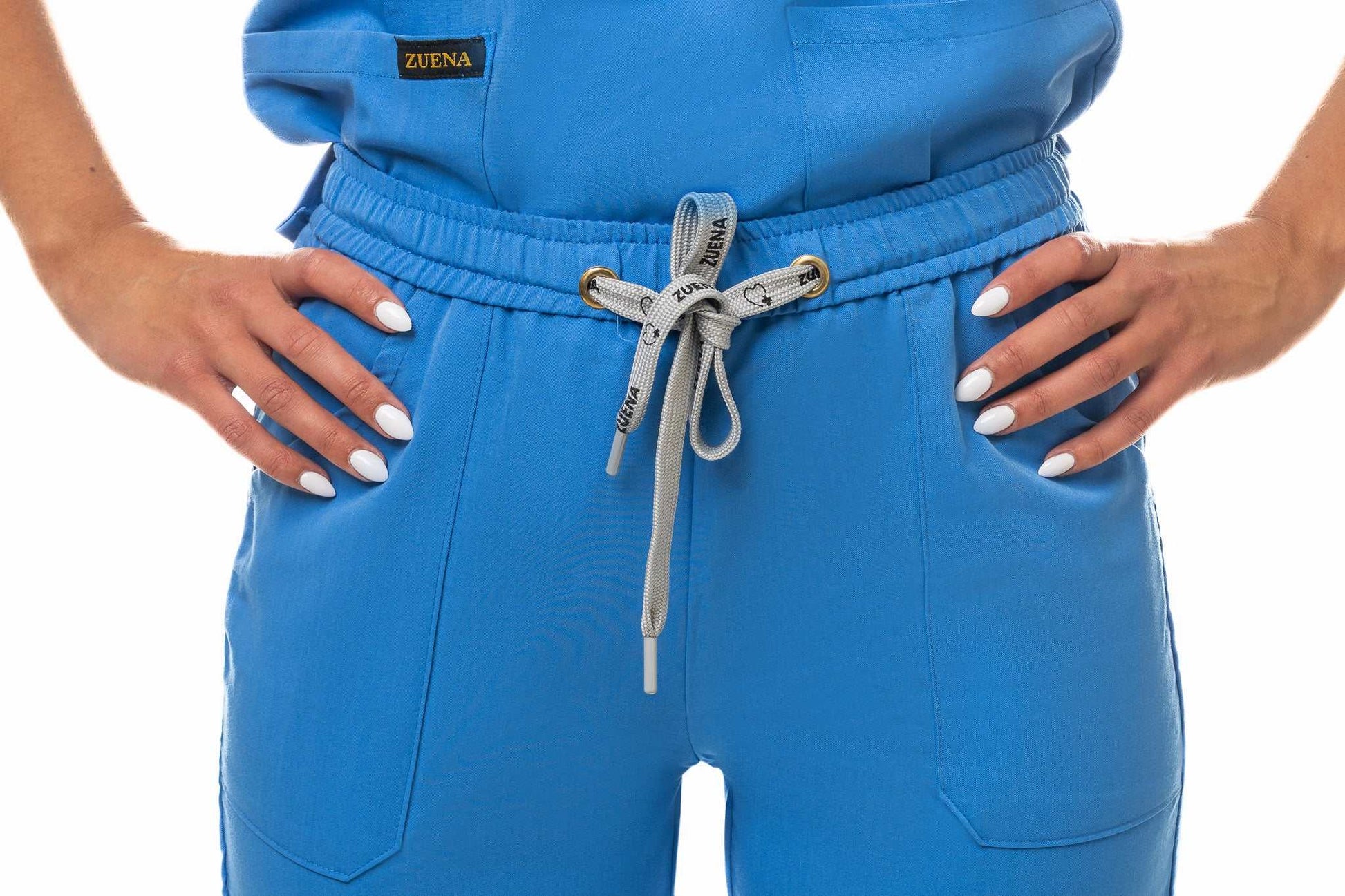 Close-up of Zuena Skyward Bound blue scrub bottom with elastic waistband and multiple pockets