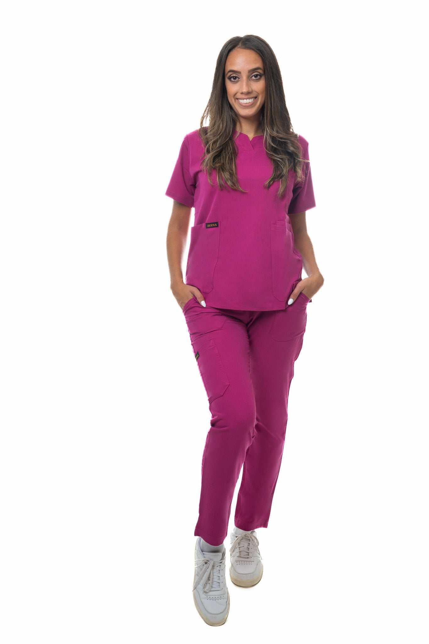 Woman wearing magenta Zuena Rose Petal Scrub Pants with elastic waistband and multiple pockets, styled for comfort and durability